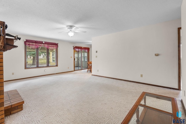 unfurnished living room with ceiling fan, carpet floors, and a textured ceiling