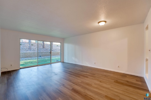 spare room with a textured ceiling and hardwood / wood-style flooring