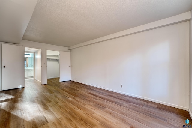 empty room featuring a textured ceiling and hardwood / wood-style flooring