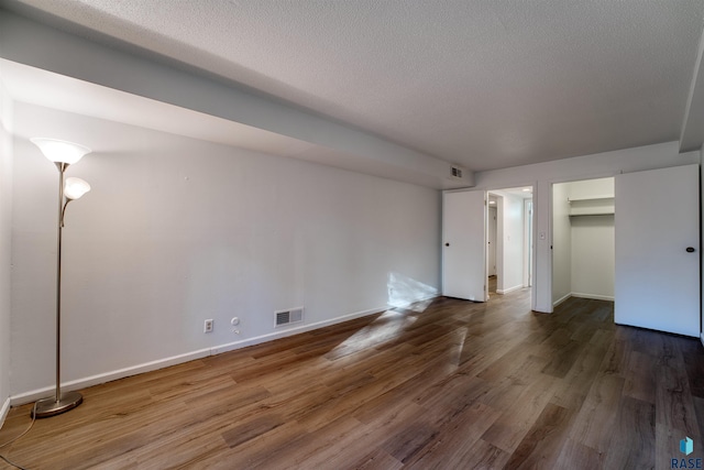 interior space featuring a textured ceiling and dark wood-type flooring