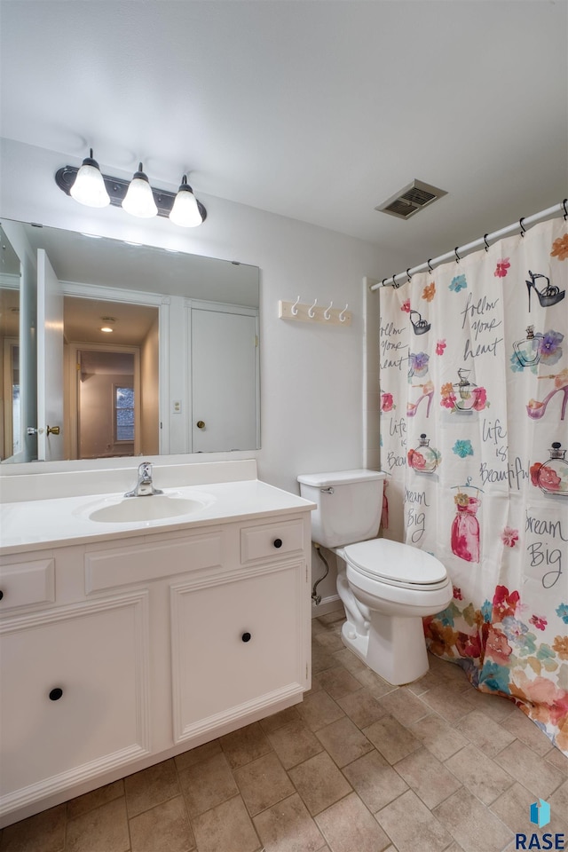 bathroom with vanity, toilet, and curtained shower