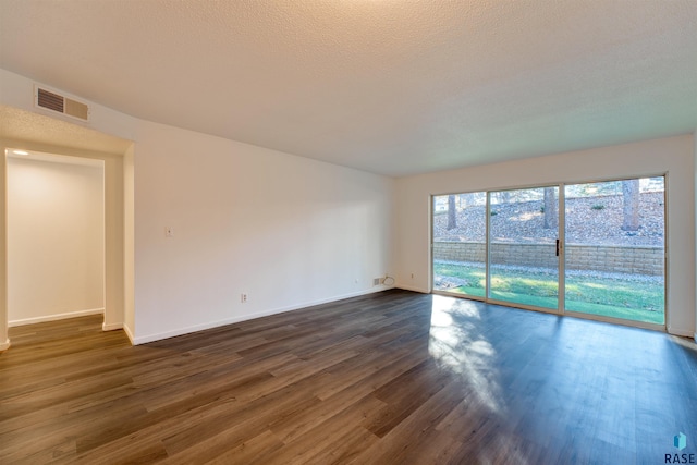 unfurnished room with dark hardwood / wood-style flooring and a textured ceiling