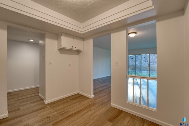 empty room featuring a textured ceiling and light hardwood / wood-style floors