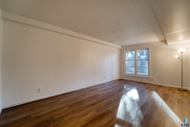 unfurnished room featuring hardwood / wood-style flooring and a textured ceiling