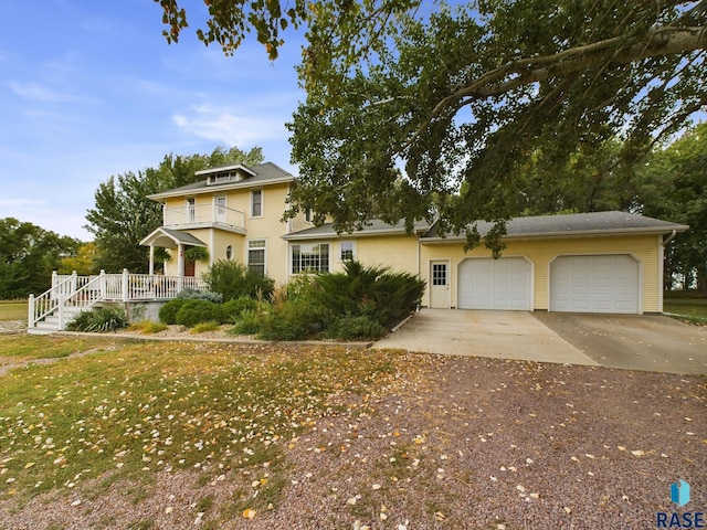 view of front of house with a garage, a balcony, and a front lawn