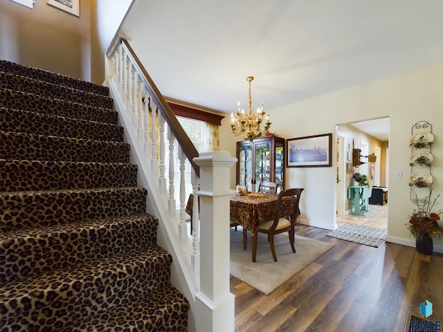 stairway with a chandelier and wood-type flooring