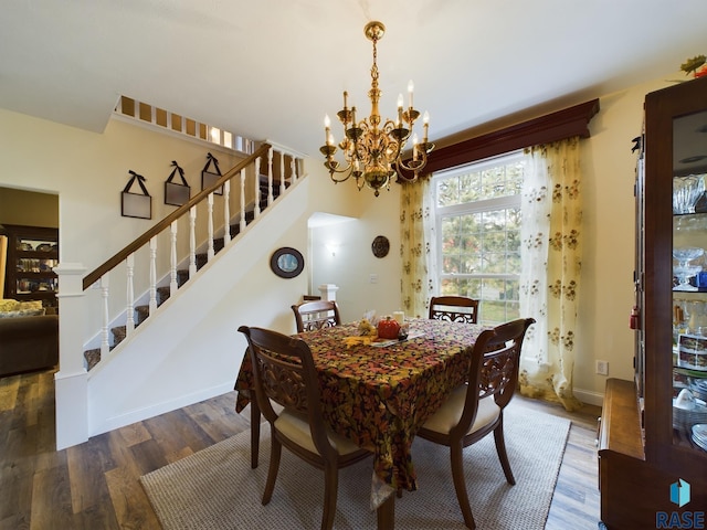 dining space with dark wood-type flooring and a notable chandelier