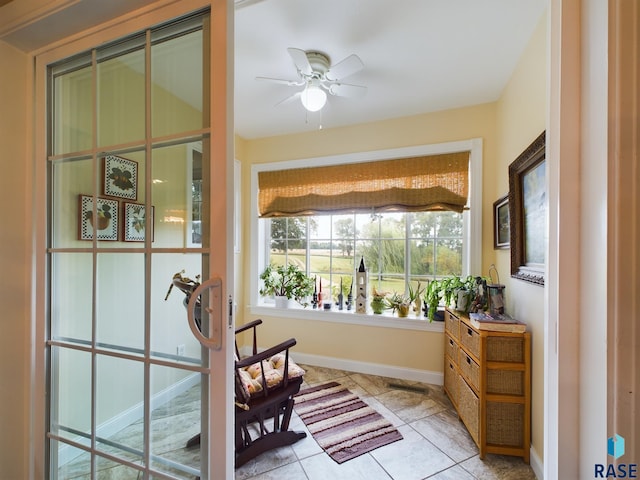 living area featuring light tile patterned floors and ceiling fan