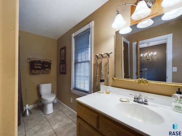 bathroom featuring toilet, tile patterned floors, vanity, and an inviting chandelier