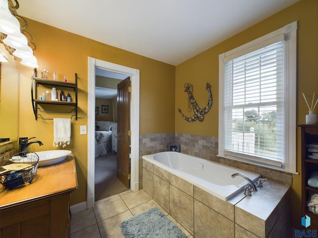 bathroom featuring tile patterned flooring, vanity, and tiled bath