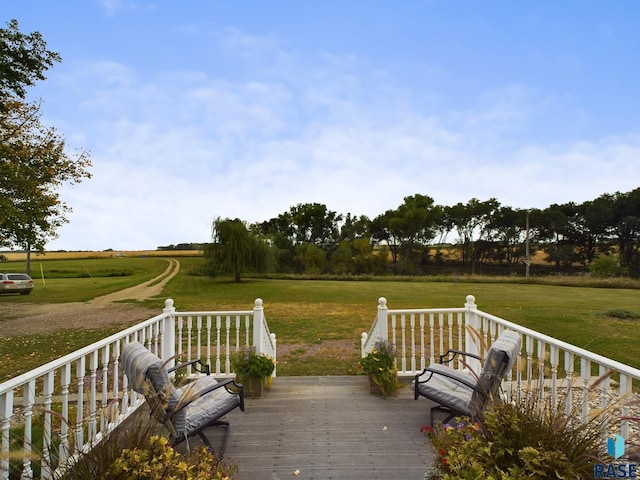 wooden terrace with a lawn and a rural view