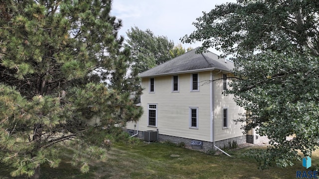 view of property exterior with a yard and cooling unit