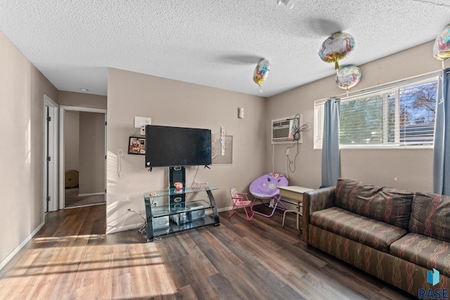 living room featuring a textured ceiling, dark hardwood / wood-style floors, and an AC wall unit