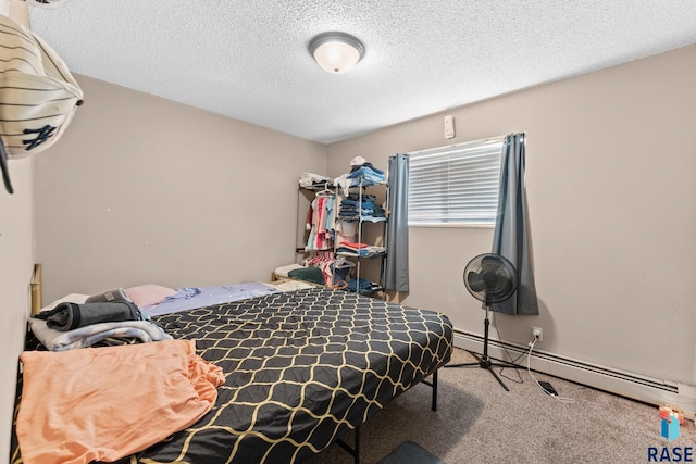 bedroom featuring carpet flooring, baseboard heating, and a textured ceiling