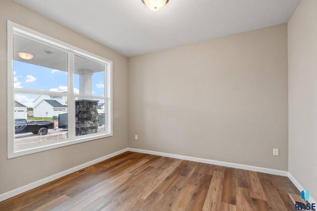 unfurnished room with hardwood / wood-style flooring