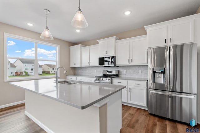 kitchen with pendant lighting, white cabinetry, sink, and stainless steel appliances