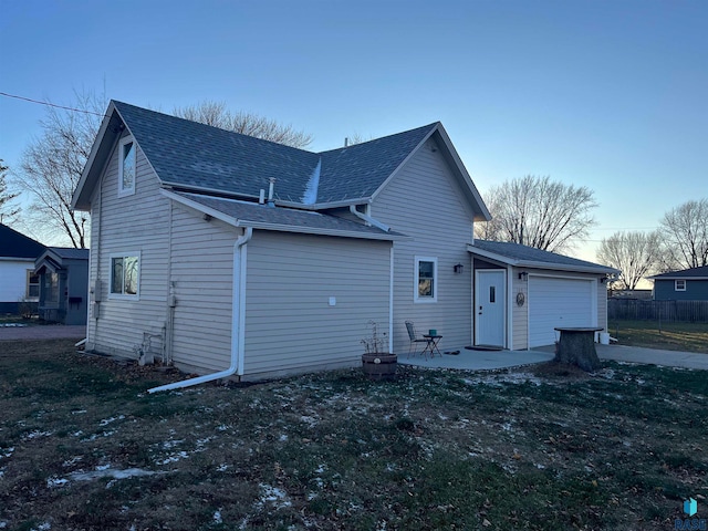 rear view of property featuring a yard and a garage