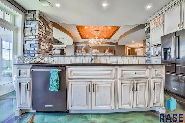 kitchen with sink, stainless steel appliances, an inviting chandelier, decorative light fixtures, and decorative backsplash