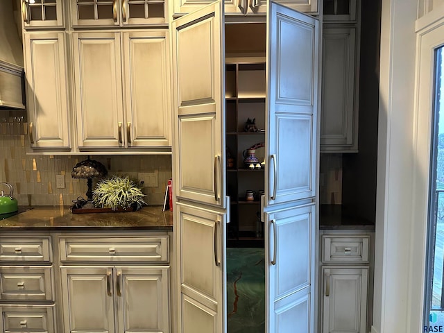 kitchen with decorative backsplash and dark stone counters