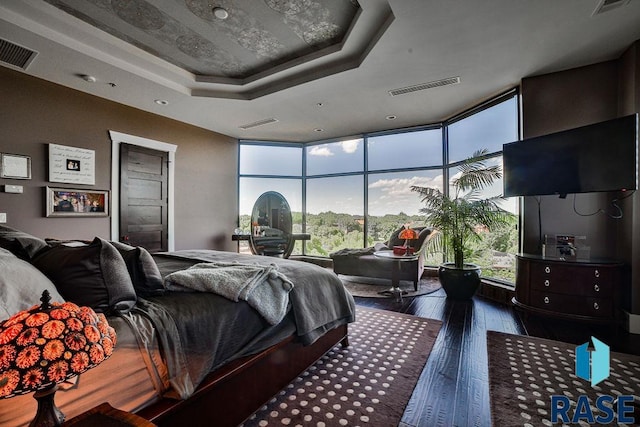 bedroom featuring a tray ceiling, floor to ceiling windows, and dark hardwood / wood-style floors