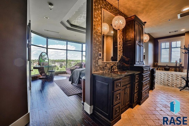 kitchen featuring plenty of natural light, dark brown cabinets, and sink