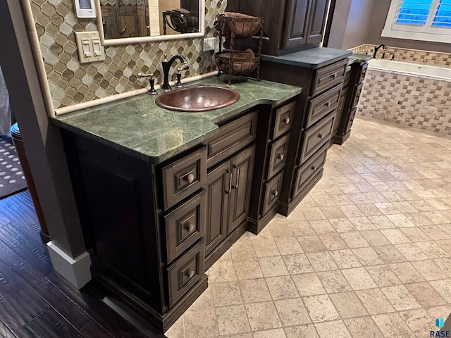 bathroom with tiled bath and vanity