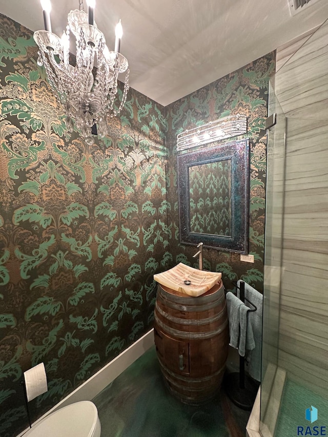 bathroom featuring a chandelier, vanity, and toilet