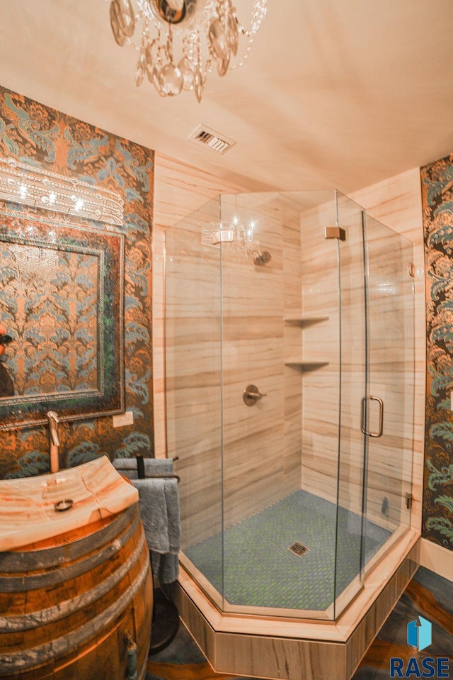 bathroom featuring a shower with door and vanity