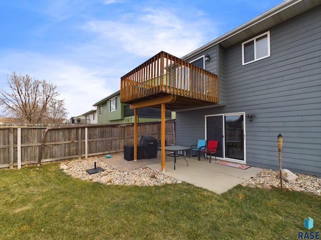 back of property featuring a lawn, a patio area, and a wooden deck