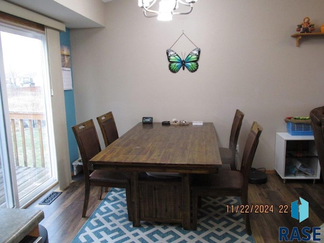 dining space with a wealth of natural light, hardwood / wood-style floors, and an inviting chandelier