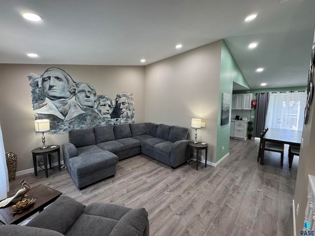 living room with light wood-type flooring and vaulted ceiling