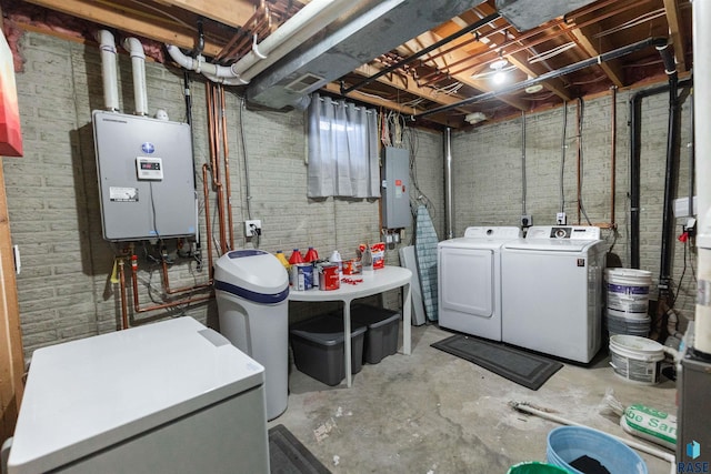 basement featuring electric panel, washer and clothes dryer, and refrigerator