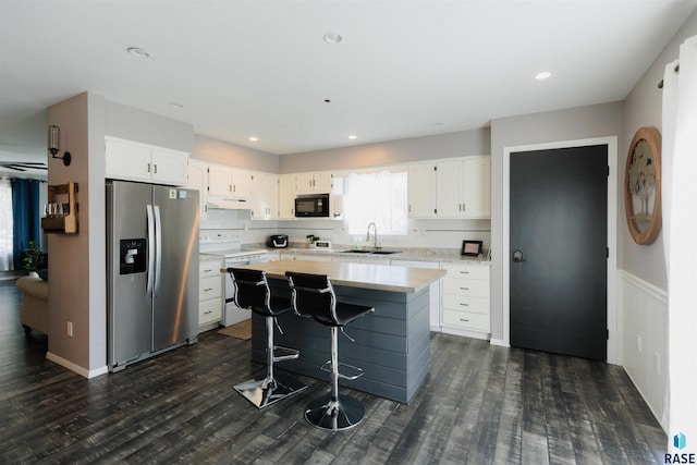 kitchen featuring white cabinets, stainless steel fridge, white electric range, and sink