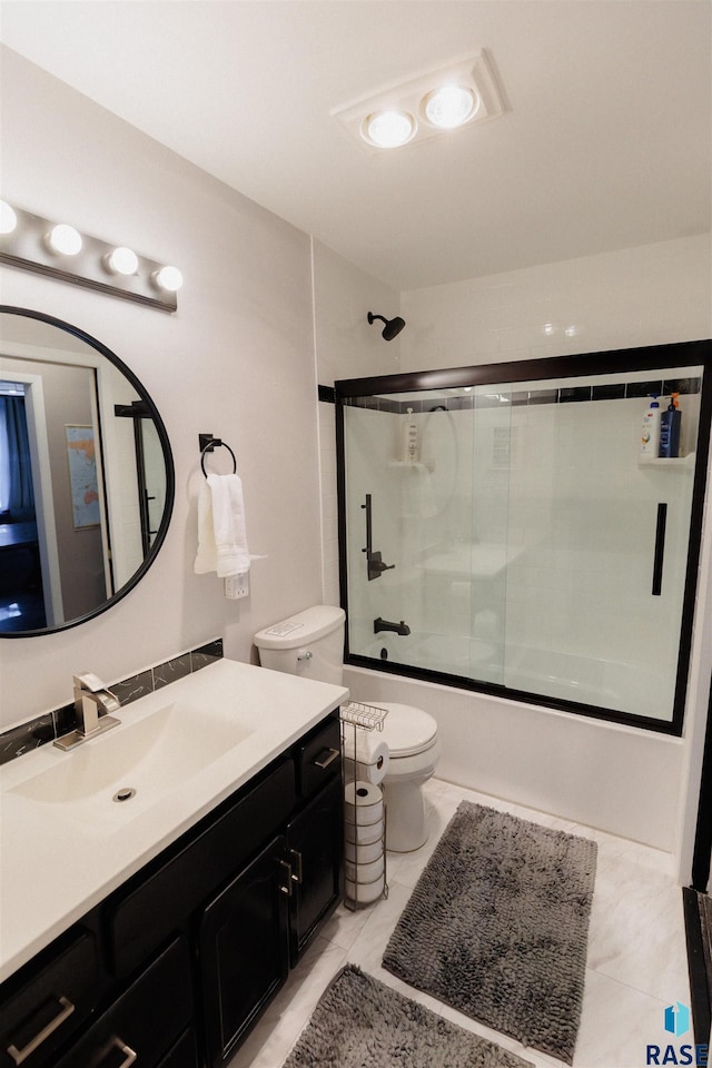 full bathroom featuring tile patterned floors, vanity, bath / shower combo with glass door, and toilet