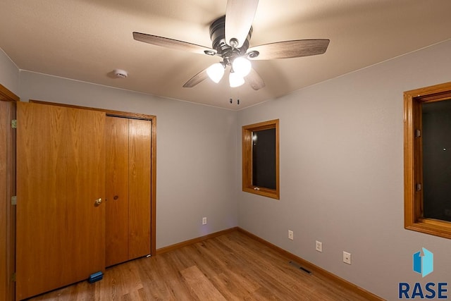 unfurnished bedroom with ceiling fan, a closet, and light hardwood / wood-style flooring