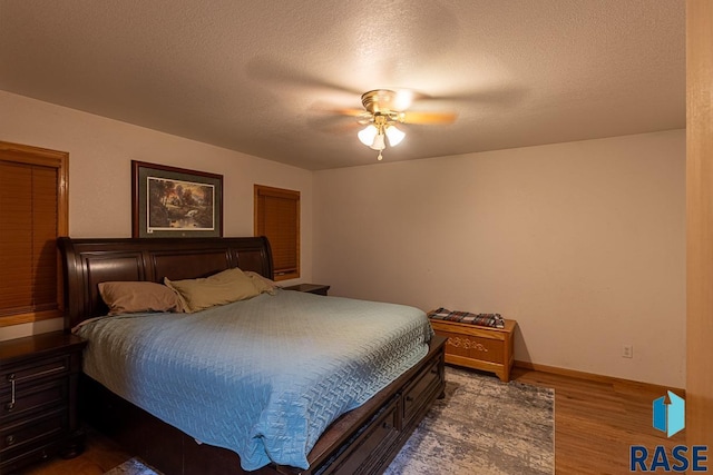 bedroom with ceiling fan, a textured ceiling, and hardwood / wood-style flooring