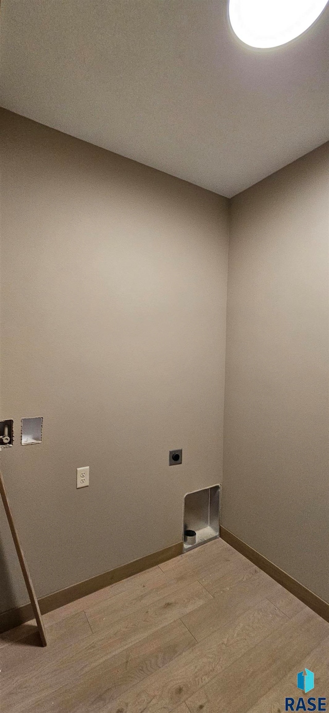 clothes washing area featuring hookup for an electric dryer and wood-type flooring