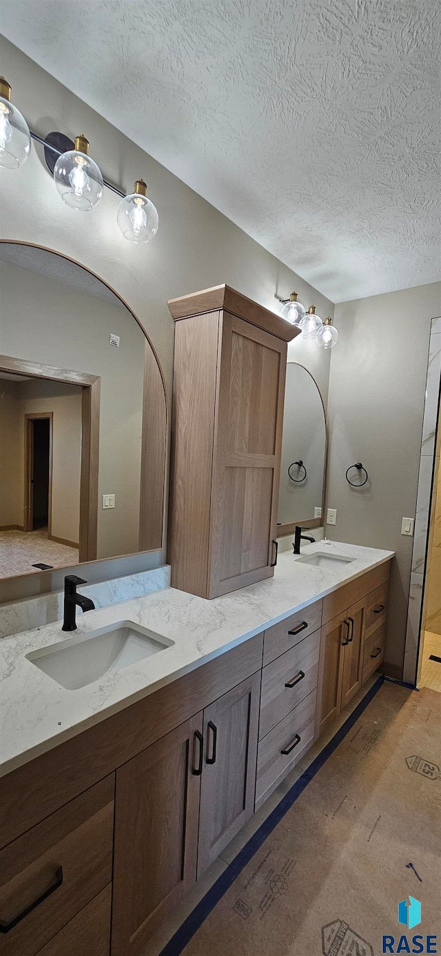 bathroom featuring hardwood / wood-style flooring, vanity, and a textured ceiling