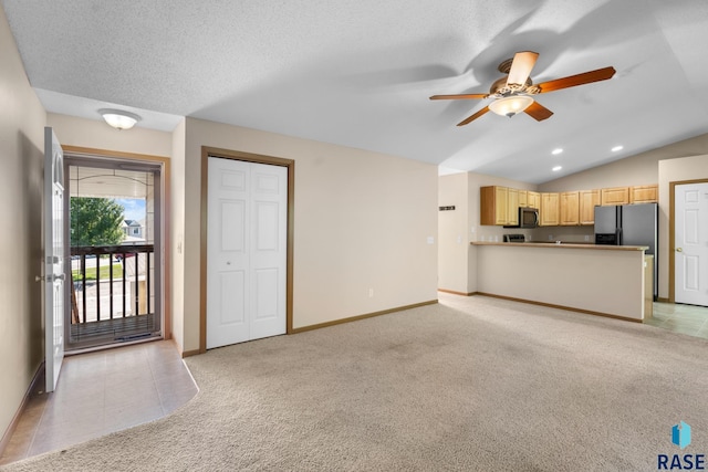 unfurnished living room featuring ceiling fan, a textured ceiling, light carpet, and vaulted ceiling