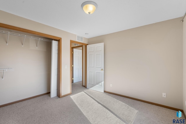 unfurnished bedroom featuring light carpet and a closet