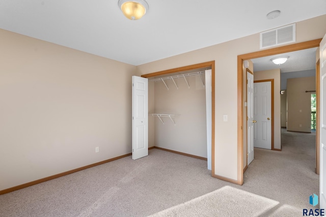 unfurnished bedroom with light carpet and a closet