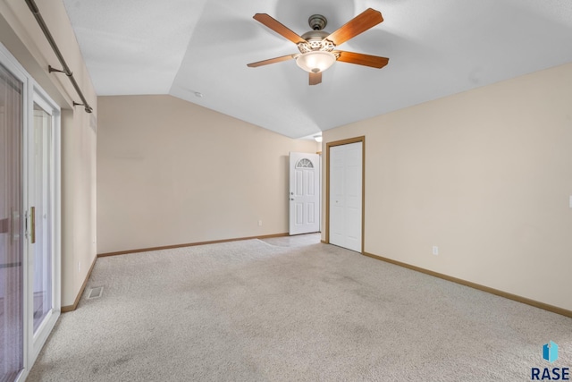 unfurnished bedroom with ceiling fan, light colored carpet, and vaulted ceiling