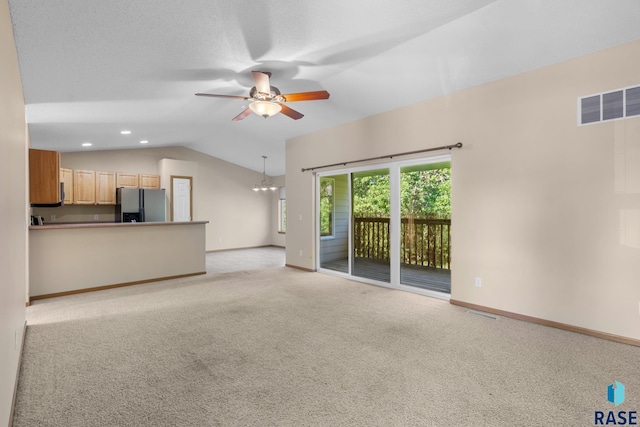 unfurnished living room featuring light carpet, ceiling fan with notable chandelier, and lofted ceiling