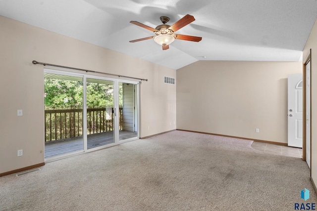 empty room featuring ceiling fan, light colored carpet, and vaulted ceiling