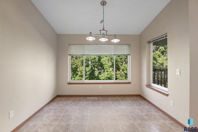 spare room featuring an inviting chandelier and vaulted ceiling