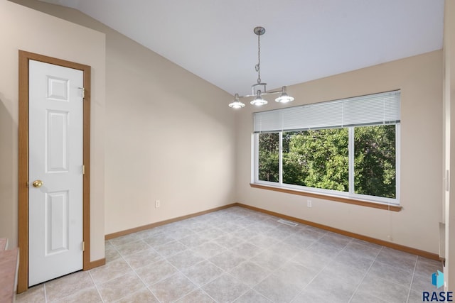 empty room with light tile patterned floors and vaulted ceiling