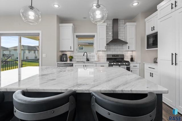 2704 S Snow Mass Ave, Sioux Falls, SD 57110 - kitchen featuring stainless steel appliances, wall chimney range hood, a sink, tasteful backsplash, and white cabinets