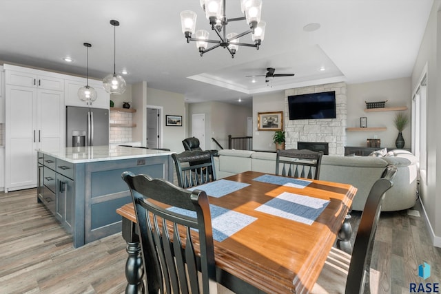 2704 S Snow Mass Ave, Sioux Falls, SD 57110 - dining area with a tray ceiling, ceiling fan, recessed lighting, a chandelier, and light wood-type flooring
