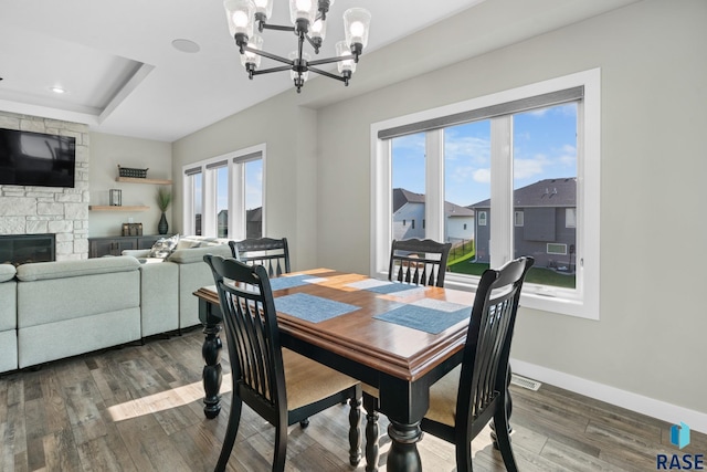 2704 S Snow Mass Ave, Sioux Falls, SD 57110 - dining room featuring a chandelier, wood finished floors, a tray ceiling, baseboards, and a stone fireplace