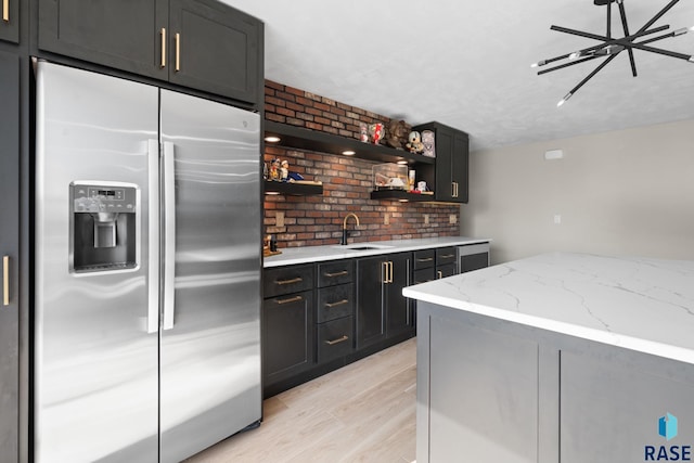 2704 S Snow Mass Ave, Sioux Falls, SD 57110 - kitchen with stainless steel fridge, light wood-style floors, a sink, light stone countertops, and open shelves